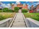 Charming brick home featuring lush landscaping and a welcoming front entrance with concrete stairs at 3070 Colorado Blvd, Denver, CO 80207