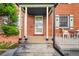Close-up of a charming red brick front porch featuring a sheltered area with white columns at 3070 Colorado Blvd, Denver, CO 80207