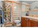 Cozy bathroom featuring a glass block shower wall, unique tile flooring, and a wooden vanity at 7400 W Quincy Ave, Littleton, CO 80123