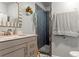 Modern bathroom featuring a single sink vanity with drawers and a tiled shower with a glass door at 7400 W Quincy Ave, Littleton, CO 80123