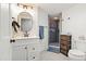 Updated bathroom featuring a modern vanity, decorative mirror, and a tiled walk-in shower at 7400 W Quincy Ave, Littleton, CO 80123
