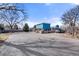 Bright blue two-story home featuring a spacious parking area and unique architectural details at 7400 W Quincy Ave, Littleton, CO 80123