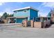 Bright blue two-story home featuring a garage, gated courtyard, and unique chimney design at 7400 W Quincy Ave, Littleton, CO 80123