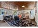 Bright sunroom with a wood paneled ceiling, a patterned rug, several chairs and a view of the front yard at 7400 W Quincy Ave, Littleton, CO 80123