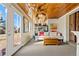 Bright sunroom with wood ceiling, striped sofa, French doors, and outdoor views at 7400 W Quincy Ave, Littleton, CO 80123