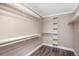 Walk-in closet featuring white shelving and dark wood floors at 7040 E Girard Ave # 104, Denver, CO 80224