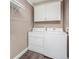 Convenient laundry room with a side-by-side washer and dryer, plus overhead storage cabinets at 7040 E Girard Ave # 104, Denver, CO 80224
