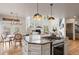 Open kitchen features island cooktop with seating, dining area, and living room view at 5170 Pinyon Jay Rd, Parker, CO 80134