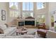 Bright living room featuring a stone fireplace, large windows, and modern decor at 5170 Pinyon Jay Rd, Parker, CO 80134
