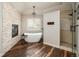 Luxurious bathroom featuring a soaking tub, stone accent wall, and modern shower at 5170 Pinyon Jay Rd, Parker, CO 80134