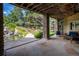 Covered patio featuring stone pillars and flagstone floors provides scenic views of the waterfall and lush landscaping at 5170 Pinyon Jay Rd, Parker, CO 80134