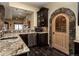 Close up of basement wet bar with granite counters, stone accents, and wine cellar at 5170 Pinyon Jay Rd, Parker, CO 80134