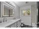 Bathroom featuring double sinks, a modern vanity, stylish fixtures, and a bright window at 4585 S Elati St, Englewood, CO 80110