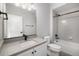 Well-lit bathroom features a gray countertop, a shower-tub combo with gray patterned tile at 2078 S Holly St # 2, Denver, CO 80222