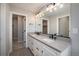 Bathroom with double vanity, gray counters, a large mirror, and modern fixtures at 2078 S Holly St # 2, Denver, CO 80222