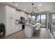 Modern white kitchen featuring an island with counter seating, stainless steel appliances, and hardwood flooring at 2078 S Holly St # 2, Denver, CO 80222