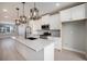 Open kitchen with modern pendant lighting, an island with sink, stainless appliances, and white cabinetry at 2078 S Holly St # 2, Denver, CO 80222