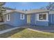 Charming blue brick home with a yellow front door and manicured lawn, offering curb appeal at 7100 E 5Th Ave, Denver, CO 80220