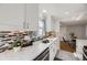 Stylish kitchen featuring sleek counters, subway tile backsplash, and a stainless steel sink with modern fixtures at 7100 E 5Th Ave, Denver, CO 80220