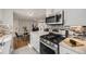 Modern kitchen with stainless steel appliances and granite counters, seamlessly connected to the open dining area at 7100 E 5Th Ave, Denver, CO 80220