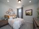 Cozy bedroom featuring a large bed, gray accent wall decorations, and a wooden dresser for storage at 21927 E 51St Dr, Aurora, CO 80019