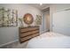 Bedroom with dresser, decorative mirror, wall art, and bed with white comforter partially visible in view at 21927 E 51St Dr, Aurora, CO 80019