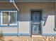 Close up of gray home with blue trim, an ornamental metal security door, and front door address at 2490 S Worchester Ct # E, Aurora, CO 80014