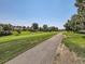 Scenic view of a walking path adjacent to the golf course with lush green grass and mature trees at 2490 S Worchester Ct # E, Aurora, CO 80014