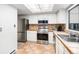 Well-lit kitchen featuring stainless steel appliances, tile floors, and sleek white cabinets at 2490 S Worchester Ct # E, Aurora, CO 80014