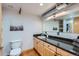 Bathroom with black countertops, light wood cabinets and a large mirror at 2715 Blake St # 2, Denver, CO 80205