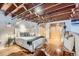 Bright bedroom featuring an exposed wood ceiling, hardwood floors, and a cowhide rug at 2715 Blake St # 2, Denver, CO 80205
