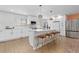 Kitchen with stainless appliances, new flooring, modern backsplash, and a large island at 6426 Zang Ct, Arvada, CO 80004
