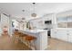 Open kitchen with white cabinets, stainless appliances, new flooring, and modern fixtures at 6426 Zang Ct, Arvada, CO 80004