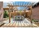 Backyard patio with an outdoor dining table set beneath a wooden pergola at 4253 Hooker St, Denver, CO 80211