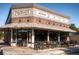 Exterior of Parisi Pizzeria, a brick corner restaurant with striped awnings and outdoor seating at 4253 Hooker St, Denver, CO 80211