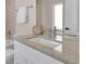 Modern bathroom features a light-filled vanity with a large mirror, neutral tiling, and refined faucet at 2140 S Ash St # 103, Denver, CO 80222