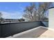 Rooftop deck features a black railing with neighborhood views and bare trees on a partly cloudy day at 2140 S Ash St # 103, Denver, CO 80222