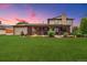 Expansive backyard features a covered porch, manicured lawn, and mature landscaping at 5954 W Leawood Dr, Littleton, CO 80123