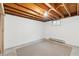 Unfinished basement provides ample space for storage or customization, featuring exposed beams and concrete flooring at 5954 W Leawood Dr, Littleton, CO 80123