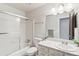 Bathroom with shower-tub combo with sliding glass door and marble vanity at 5954 W Leawood Dr, Littleton, CO 80123