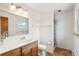 Bright bathroom with a walk-in shower, a vanity with storage, and a large mirror at 5954 W Leawood Dr, Littleton, CO 80123