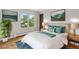 Sunlit bedroom offers a queen bed, hardwood floors, and a view of the lush backyard at 5954 W Leawood Dr, Littleton, CO 80123