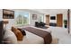 Spacious primary bedroom with neutral walls, a window overlooking the yard, and dual closets, virtually staged at 5954 W Leawood Dr, Littleton, CO 80123