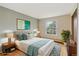 Bright bedroom features a large window, hardwood floors, and a plush queen-sized bed with stylish decor at 5954 W Leawood Dr, Littleton, CO 80123