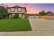 Two-story home with a spacious driveway, attached two-car garage, and a well-manicured front lawn at 5954 W Leawood Dr, Littleton, CO 80123