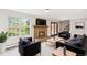Living room with a cozy fireplace, plush seating, and a view of the outdoor greenery at 5954 W Leawood Dr, Littleton, CO 80123