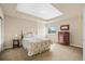 Bedroom with a floral bedspread, tray ceiling, and natural light from a window at 7859 S Coolidge Way, Aurora, CO 80016