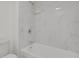 A shower and toilet combo with bright white marbled tile at 9725 E Harvard Ave # 305, Denver, CO 80231