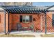 Cozy front porch with a pergola, seating area, and charming brick details, perfect for relaxing outdoors at 3641 N Cook St, Denver, CO 80205