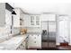 Bright kitchen features white cabinets, stainless steel appliances, and marble countertops at 3641 N Cook St, Denver, CO 80205